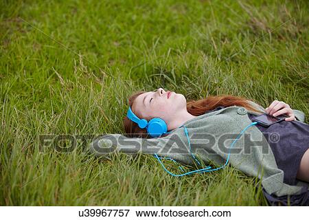 Stock Photo - Teenage girl listening to headphones. Fotosearch