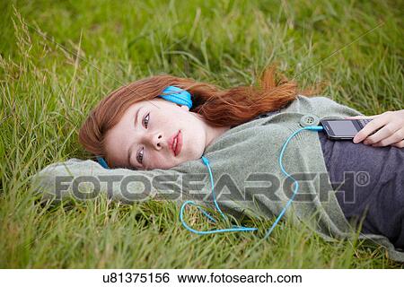 Stock Photograph - Teenage girl listening to headphones. Fotosearch