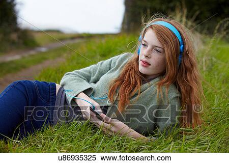 Stock Photography - Teenage girl listening to headphones. Fotosearch