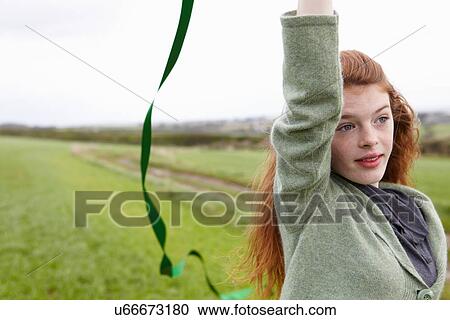 Stock Image - Teenage girl playing with ribbon. Fotosearch