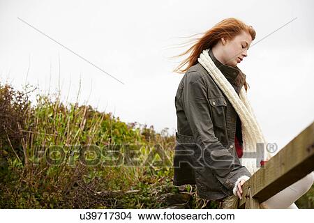 Teenage girl sitting on wooden fence View Large Photo Image Picture - Teenage girl sitting on wooden fence. Fotosearch