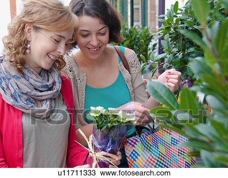 Teenage girls admiring flowers View Large Photo Image Stock Image - Teenage girls admiring flowers. Fotosearch