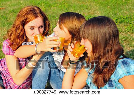 Teenage girls picnicking in rural field View Large Photo Image Stock Photo - Teenage girls picnicking in rural field. Fotosearch