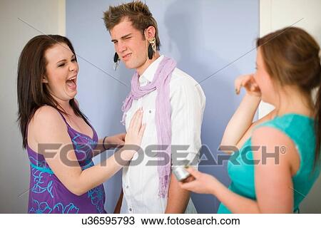 Teenage girls putting jewelry on boy View Large Photo Image Stock Image - Teenage girls putting jewelry on boy. Fotosearch