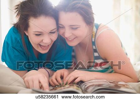 Teenage girls reading magazine together View Large Photo Image Stock Image - Teenage girls reading magazine together. Fotosearch