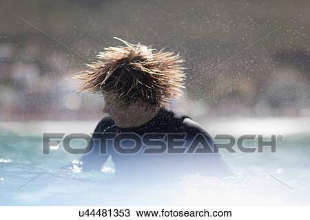 Stock Image - Teenage surfer shaking his hair. Fotosearch