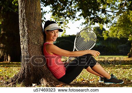 Stock Image - Tennis player resting in park. Fotosearch