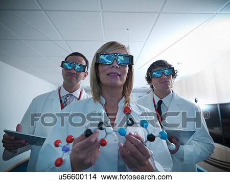 Three scientists in lab coats wearing 3D glasses and holding molecular model View Large Photo Image Picture - Three scientists in lab coats wearing 3D glasses and holding molecular model. Fotosearch
