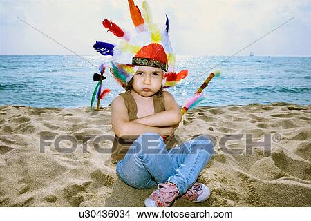 Picture - Toddler in Indian headdress on beach. Fotosearch