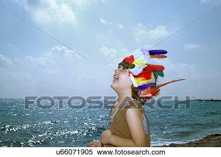 Stock Photography - Toddler in Indian headdress on beach. Fotosearch