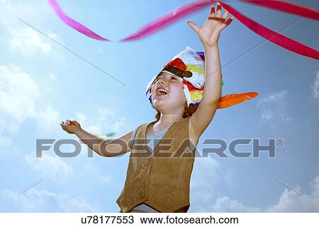 Stock Image - Toddler in Indian headdress with ribbon. Fotosearch