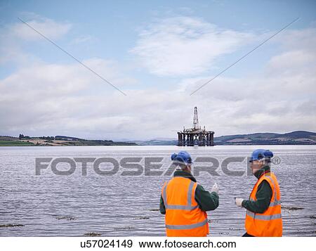 Two male environmentalists working on seashore View Large Photo Image Stock Photo - Two male environmentalists working on seashore. Fotosearch