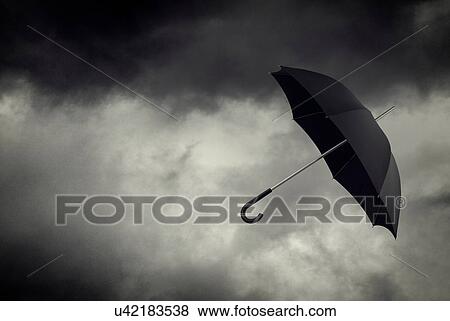 Umbrella floating in stormy sky View Large Photo Image Stock Photo - Umbrella floating in stormy sky. Fotosearch