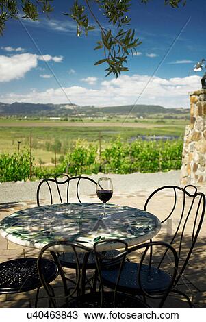 Stock Image - Wine glass on a table outdoors. Fotosearch