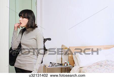 Stock Image - Woman admiring herself in mirror. Fotosearch