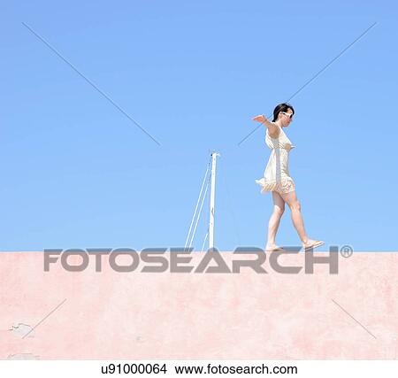 Woman balancing on wall View Large Photo Image Picture - Woman balancing on wall. Fotosearch