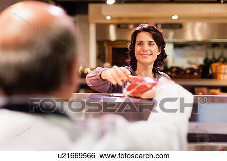 Woman buying meat from butcher View Large Photo Image Stock Photograph - Woman buying meat from butcher. Fotosearch