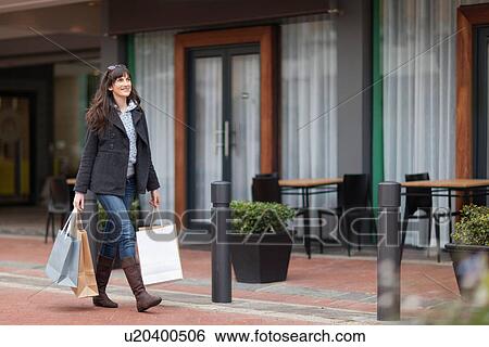 Woman carrying shopping bags on street View Large Photo Image Stock Photograph - Woman carrying shopping bags on street. Fotosearch