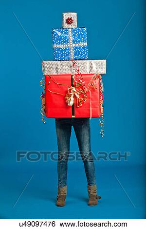 Woman carrying wrapped gifts View Large Photo Image Stock Photograph - Woman carrying wrapped gifts. Fotosearch