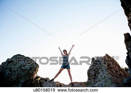 Woman cheering on rocks View Large Photo Image Stock Photo - Woman cheering on rocks. Fotosearch