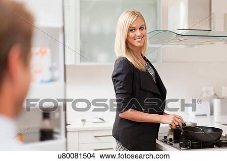 Picture - Woman cooking breakfast for husband. Fotosearch