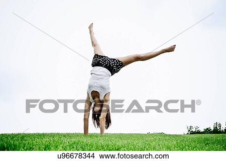 Woman doing cartwheel outdoors View Large Photo Image Picture - Woman doing cartwheel outdoors. Fotosearch