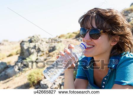 Woman drinking bottle of water outdoors View Large Photo Image Stock Photo - Woman drinking bottle of water outdoors. Fotosearch