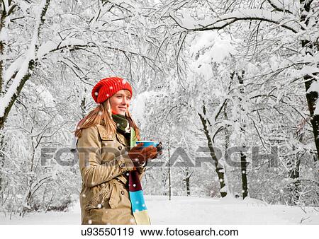 Stock Photo - Woman drinking coffee in snow. Fotosearch