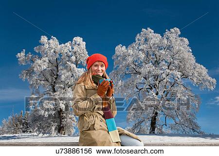 Stock Photograph - Woman drinking coffee in snow. Fotosearch