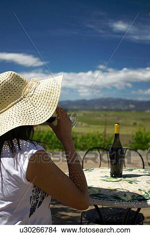 Woman drinking wine at table outdoors View Large Photo Image Picture - Woman drinking wine at table outdoors. Fotosearch