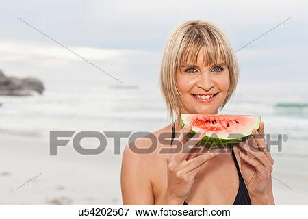 Woman eating watermelon on beach View Large Photo Image Stock Photo - Woman eating watermelon on beach. Fotosearch