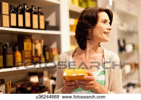 Stock Photo - Woman examining box in store. Fotosearch