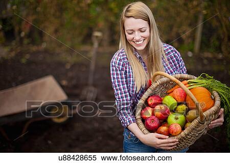 Woman gathering vegetables in garden View Large Photo Image Stock Photography - Woman gathering vegetables in garden. Fotosearch