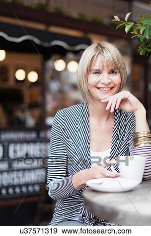 Woman having coffee at sidewalk cafe View Large Photo Image Stock Photo - Woman having coffee at sidewalk cafe. Fotosearch