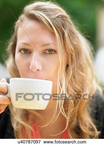 Stock Photo - Woman having coffee at sidewalk cafe. Fotosearch