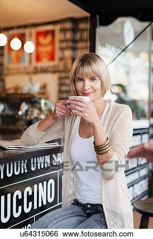 Stock Photograph - Woman having coffee at sidewalk cafe. Fotosearch