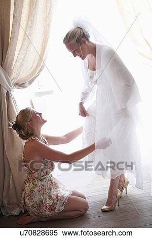 Woman helping bride get dressed View Large Photo Image Stock Photography - Woman helping bride get dressed. Fotosearch