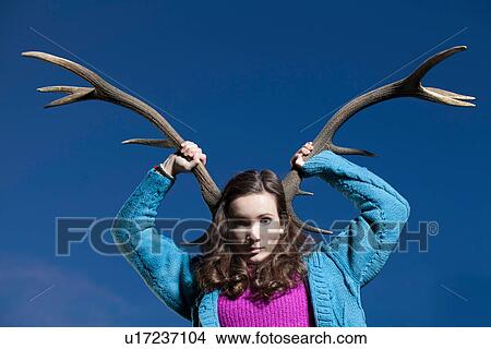 Woman holding antlers on head View Large Photo Image Picture - Woman holding antlers on head. Fotosearch