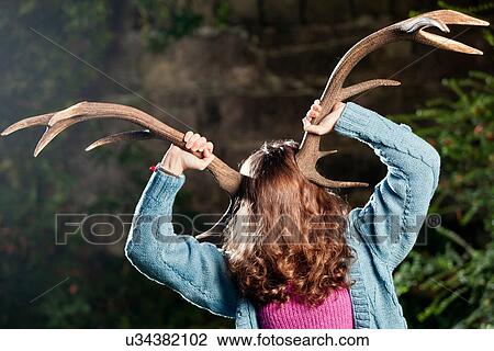 Woman holding antlers on head View Large Photo Image Stock Image - Woman holding antlers on head. Fotosearch