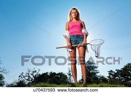 Stock Image - Woman holding butterfly net outdoors. Fotosearch