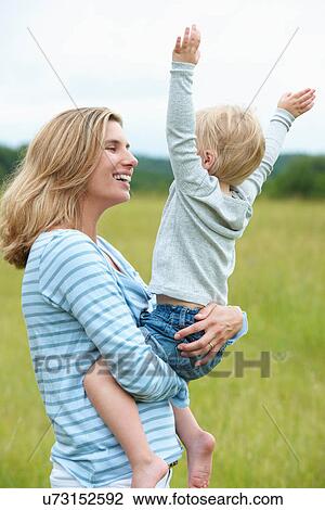 Woman holding cheering son outdoors View Large Photo Image Stock Image - Woman holding cheering son outdoors. Fotosearch