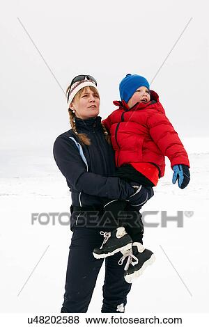 Woman holding child in snow View Large Photo Image Stock Photo - Woman holding child in snow. Fotosearch