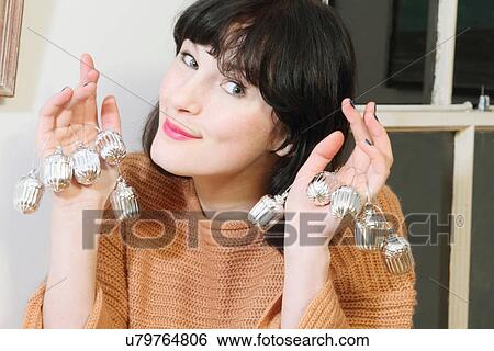 Stock Photograph - Woman holding Christmas ornaments. Fotosearch