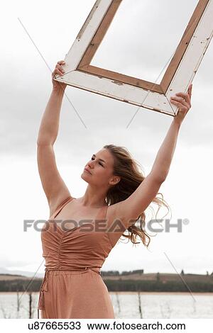 Woman holding empty picture frame View Large Photo Image Stock Image - Woman holding empty picture frame. Fotosearch