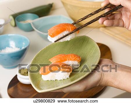 Woman holding plate of sushi View Large Photo Image Stock Photo - Woman holding plate of sushi. Fotosearch