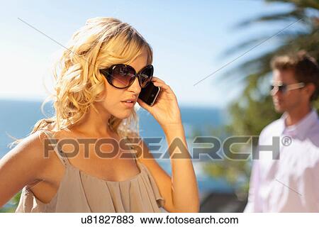 Stock Image - Woman ignoring boyfriend for cell phone. Fotosearch