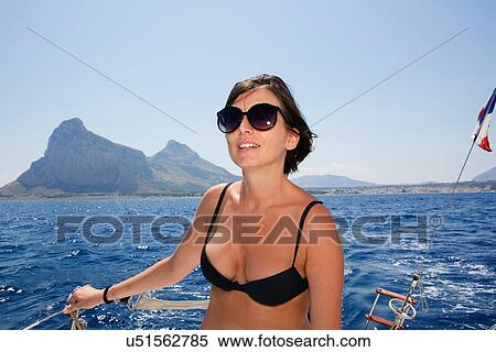 Woman in bikini standing on boat View Large Photo Image Stock Photography - Woman in bikini standing on boat. Fotosearch