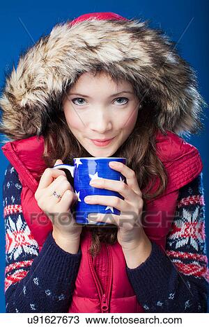 Stock Image - Woman in parka drinking coffee. Fotosearch