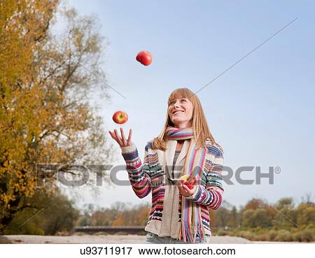 Woman juggling apples outdoors View Large Photo Image Stock Photo - Woman juggling apples outdoors. Fotosearch