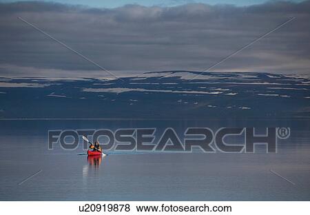 Stock Photo - Woman kayaking in still lake. Fotosearch